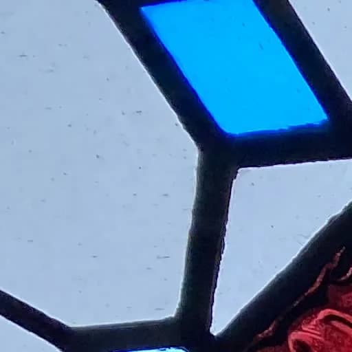 Geometric sacred stained glass close-up with rich color and lead lines