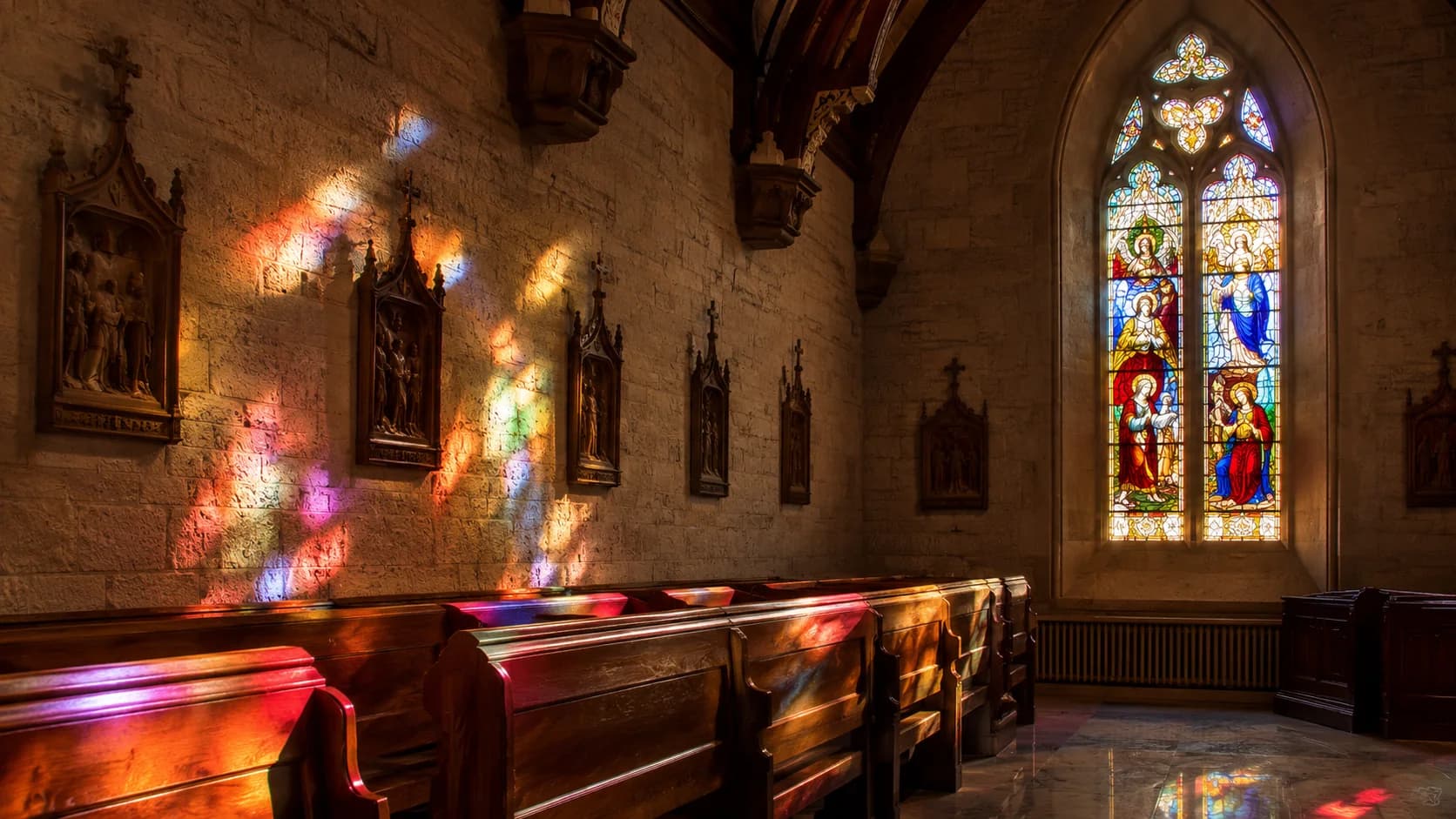 Colored light from church stained glass reflecting across a sacred interior
