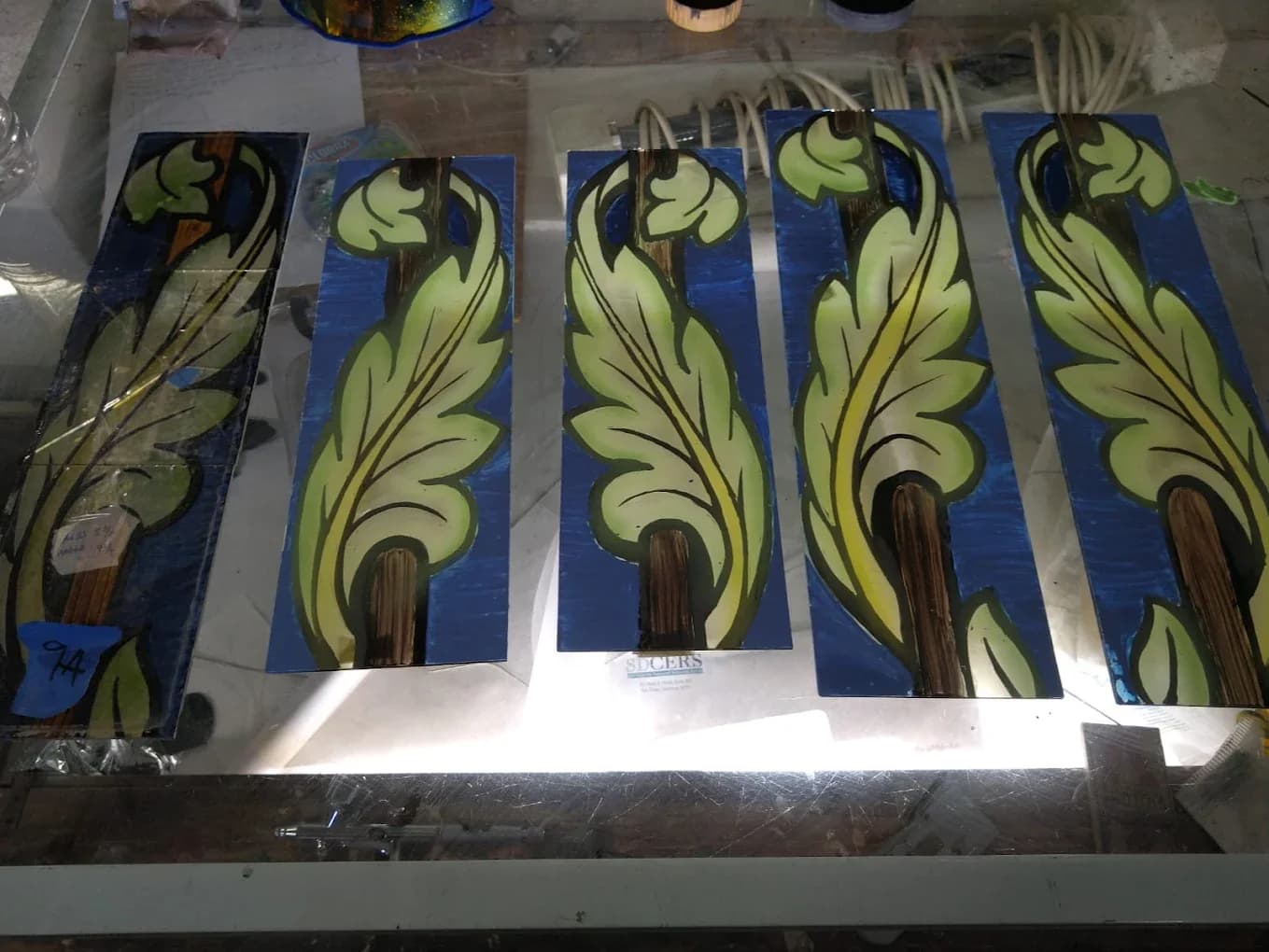 Stained glass panel restoration on a lighted workbench before reinstallation