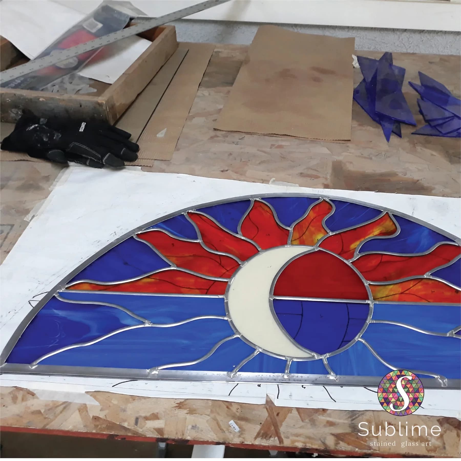 Stained glass window restoration workshop panel with red, blue and clear glass